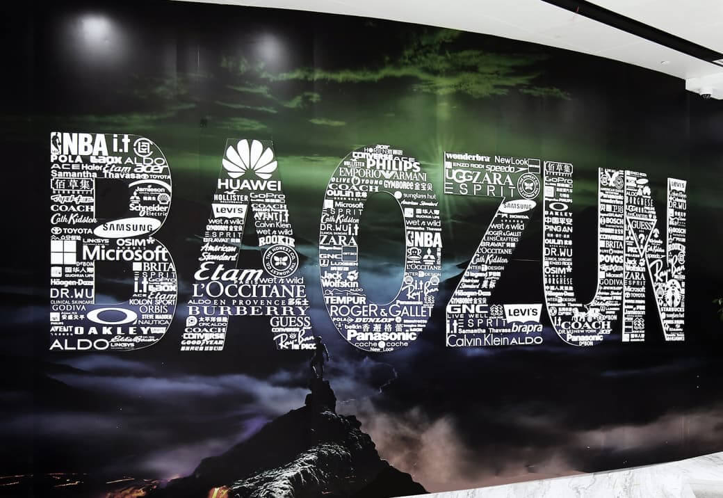 A sign that says Baozun whose letters are made up of various company names