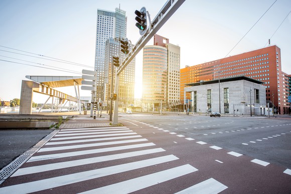 Image of an intersection with city buildings in the background.