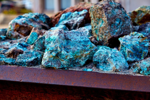 Copper ore piled on a flat metal surface