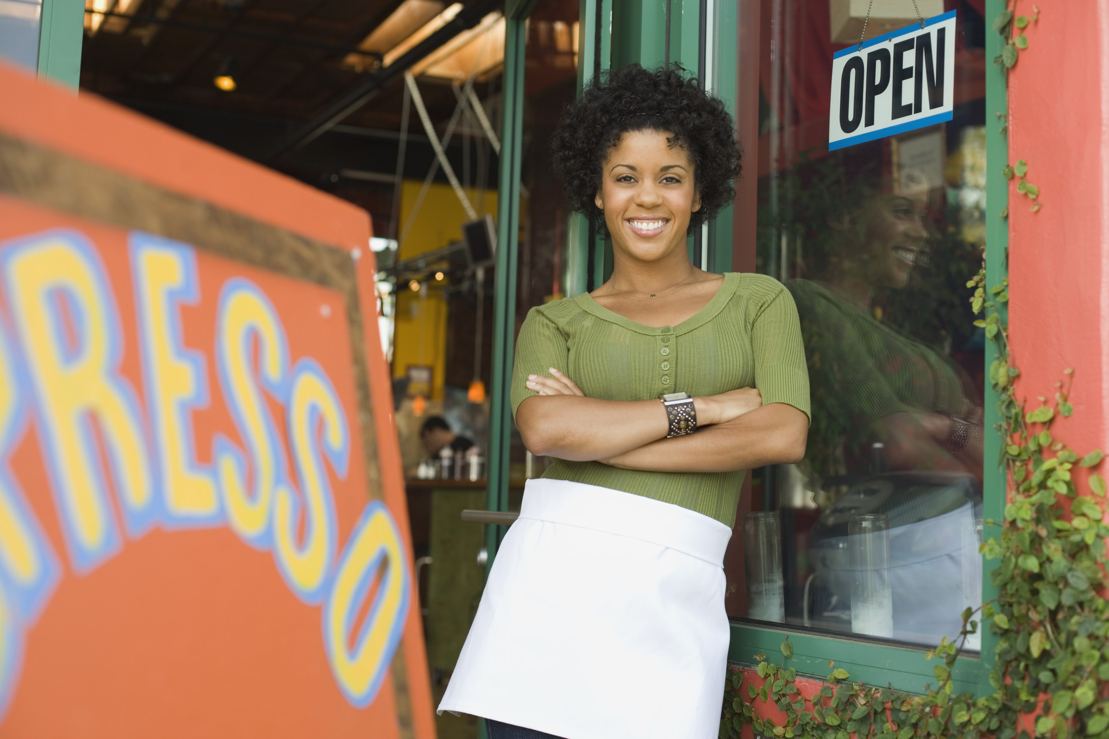 female african american food entrepreneur outside her coffee shop. 