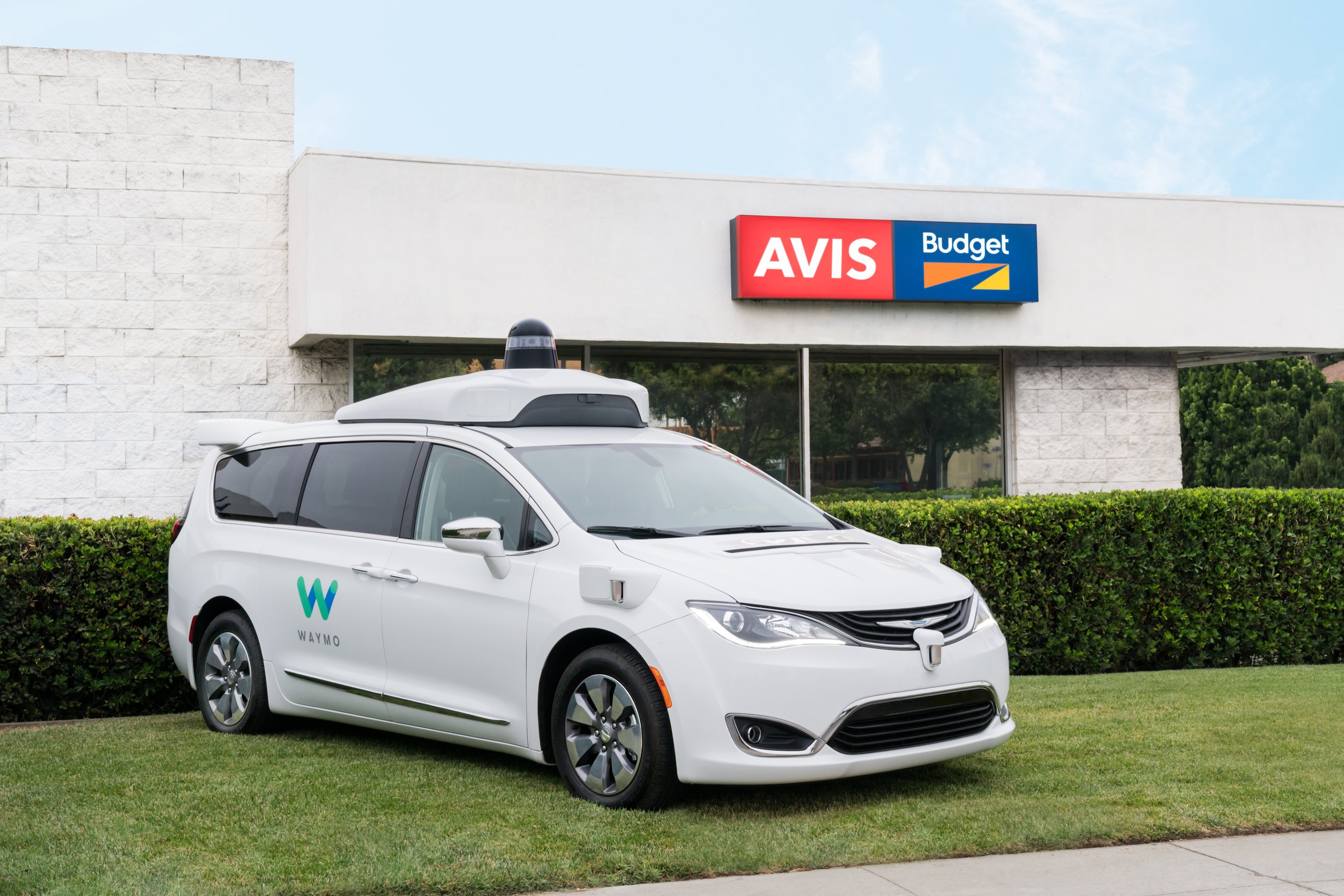 One of Waymo's self-driving Chrysler Pacifica's parked outside of an Avis Budget location.