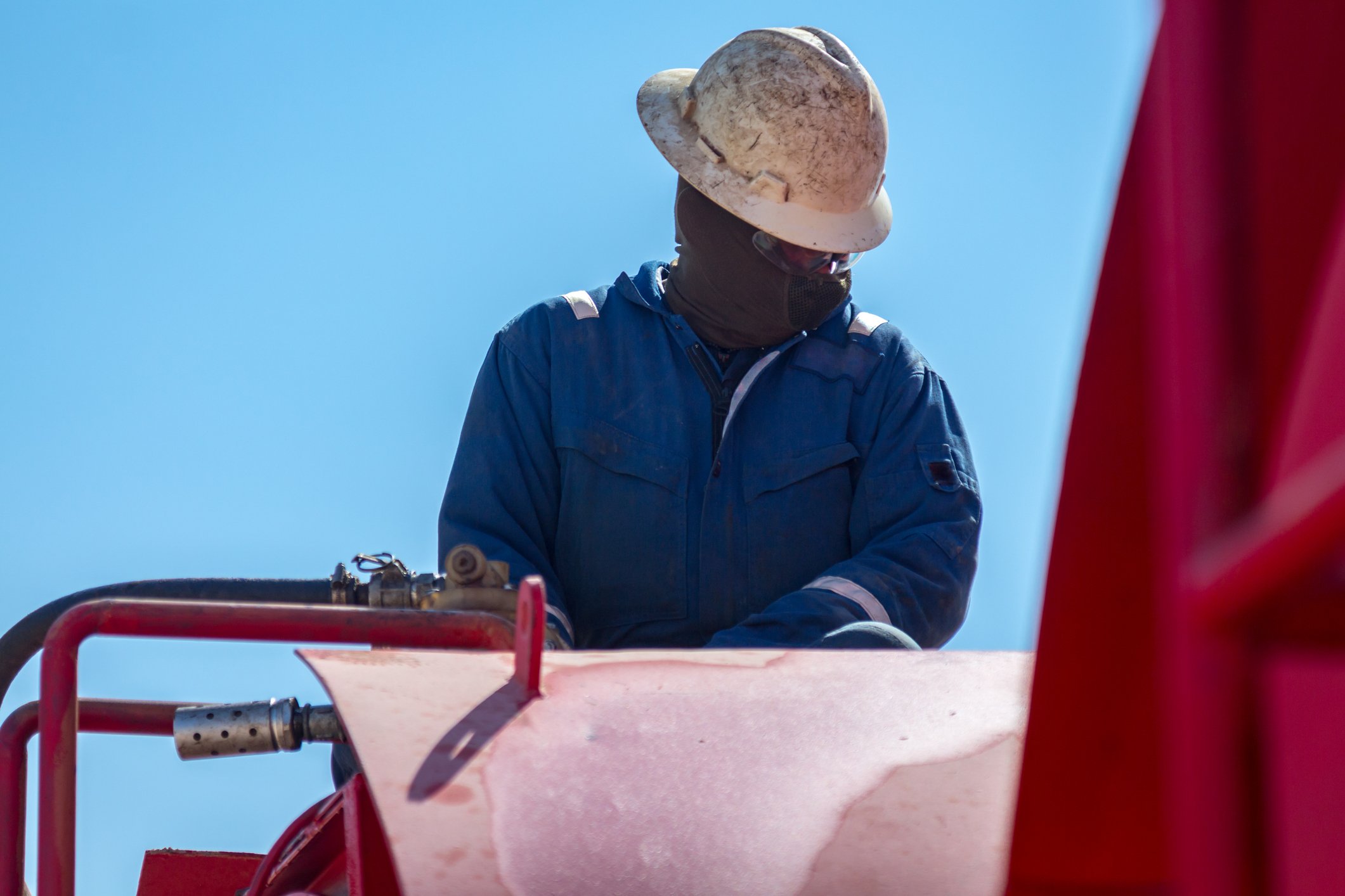 Person in a hard hat near pipes