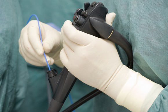 Gloved hands using an endoscope