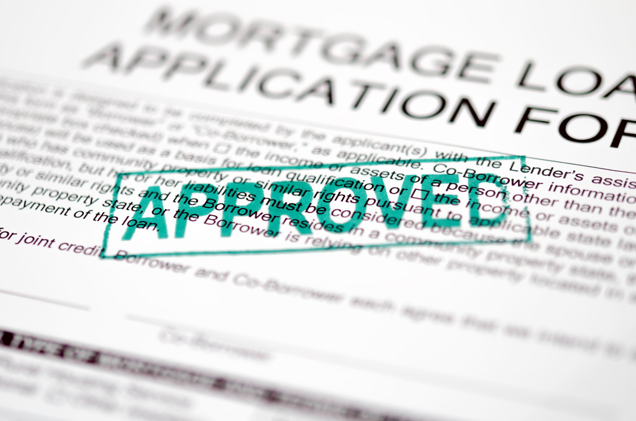 Mortgage loan application with approved stamped on top.