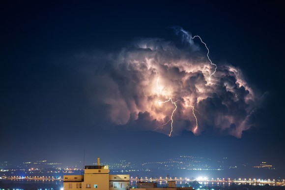 Cloud and lightning over a city at night