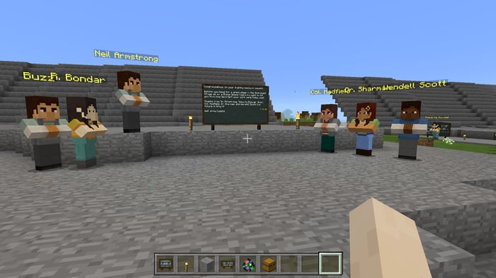 A first-person viewpoint of a Minecraft player looking at six other players.