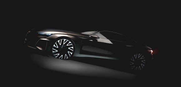 The prototype Audi e-tron GT, a low-slung four-door shown in shadows.