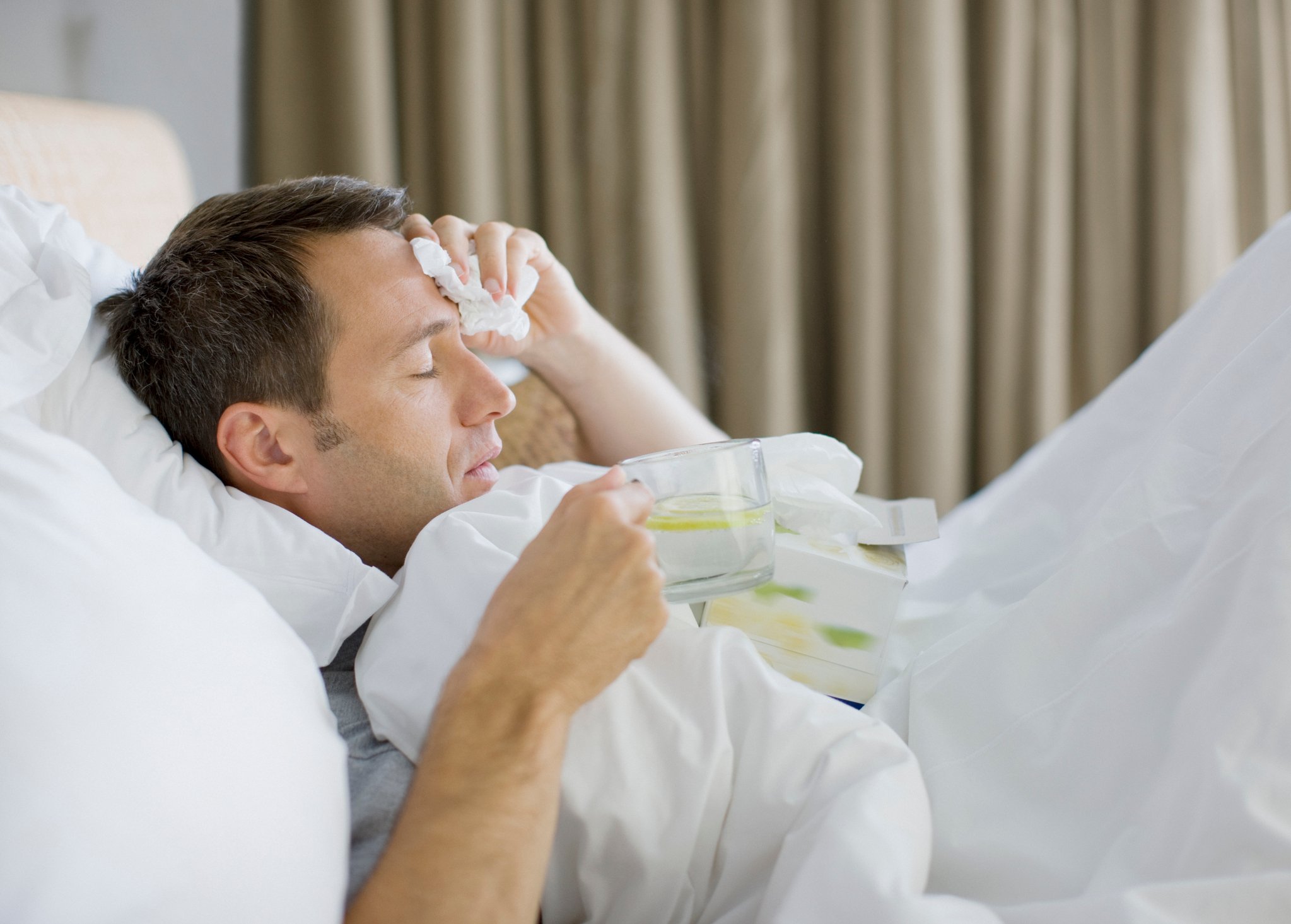 Man lying in bed as if sick
