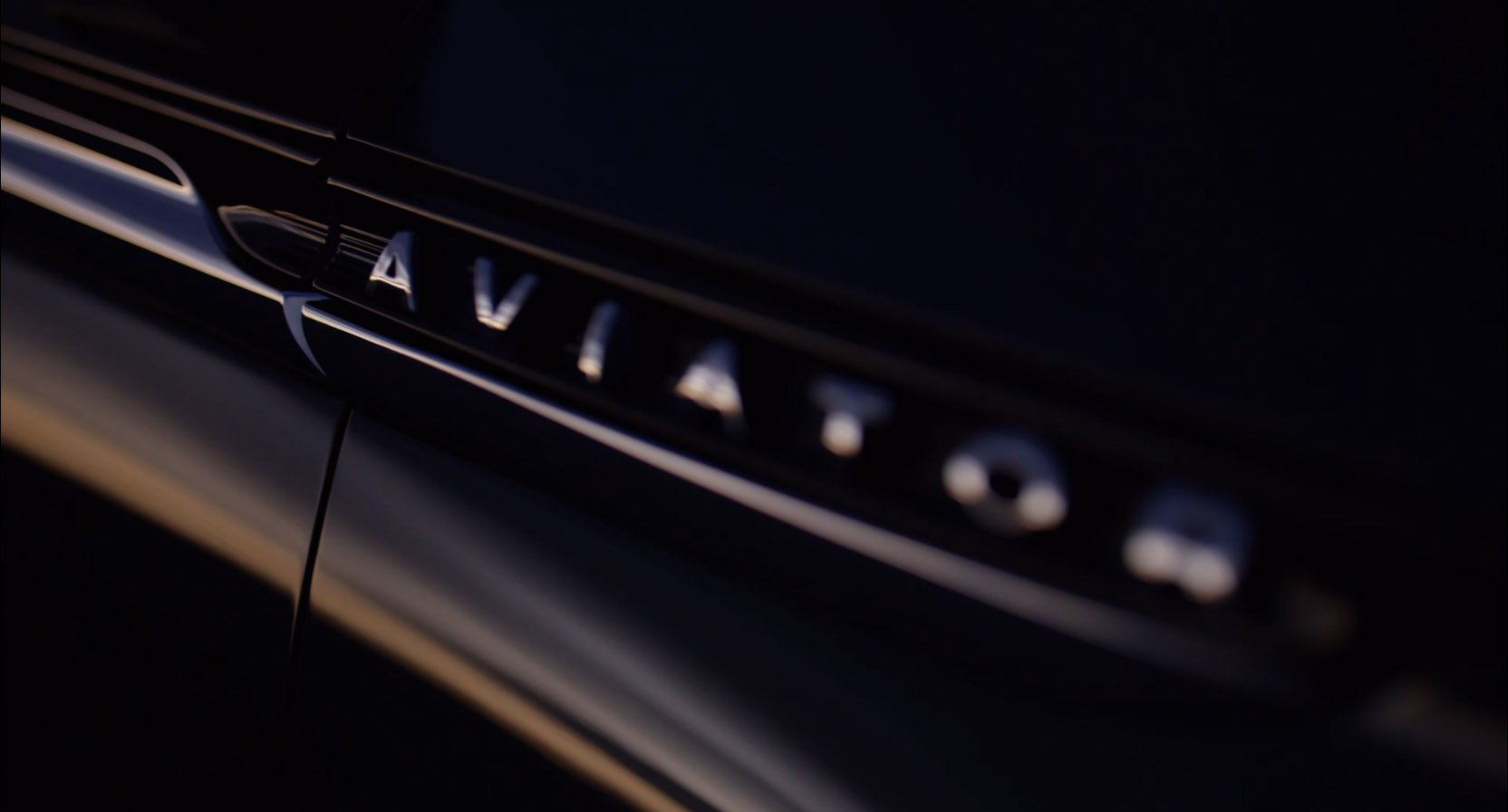 A teaser image on a vehicle exterior showing "Aviator".