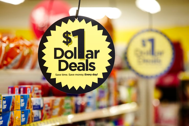 Close-up of hanging sign labeled "$1 Dollar Deals" in Dollar General store aisle.