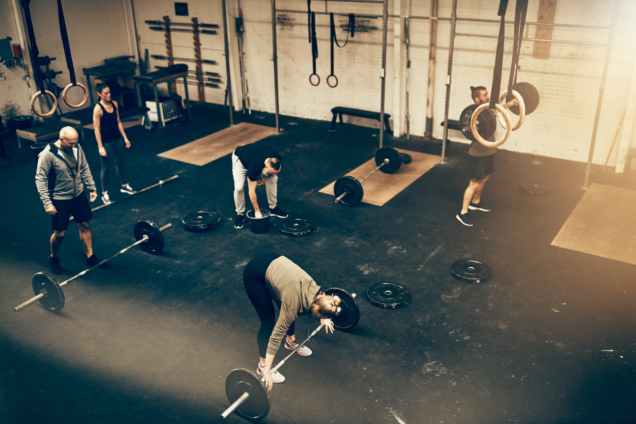 High angle of a group of fit people working out together during a weightlifting class at a gym.