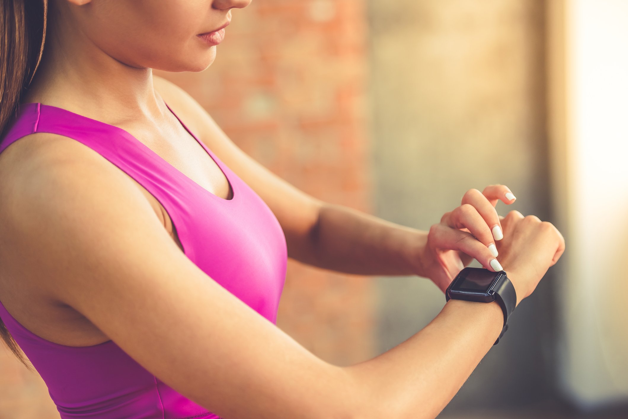 Woman in fitness clothing looking at a smartwatch