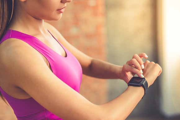 Woman in fitness clothing looking at a smartwatch