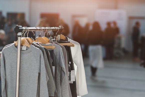 Clothes hanging on a rack inside a store.