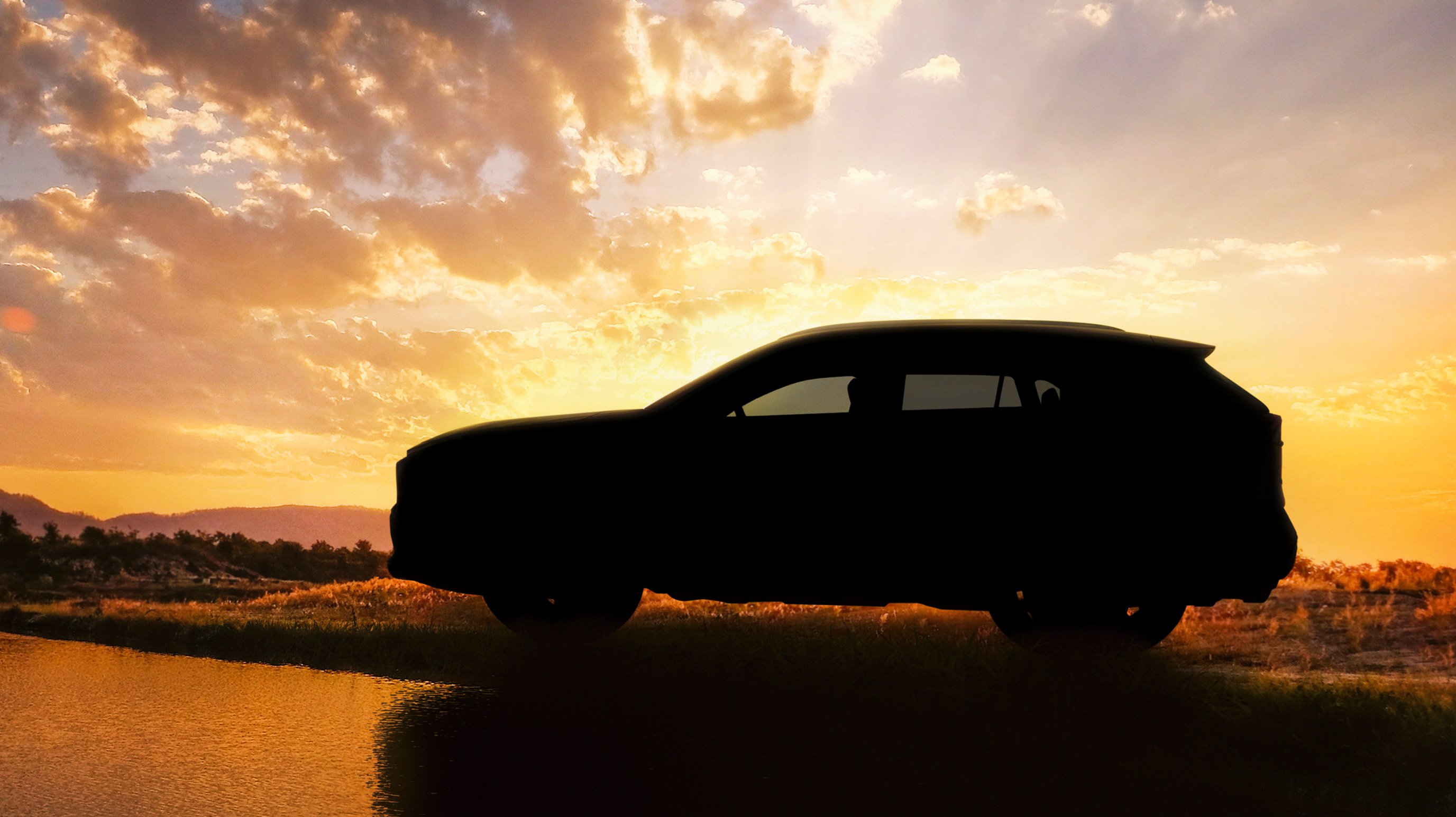 A "teaser" image showing the 2019 RAV4 in shadow, parked by a lake. 