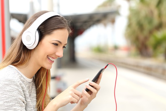 Woman listening to music on a smartphone.