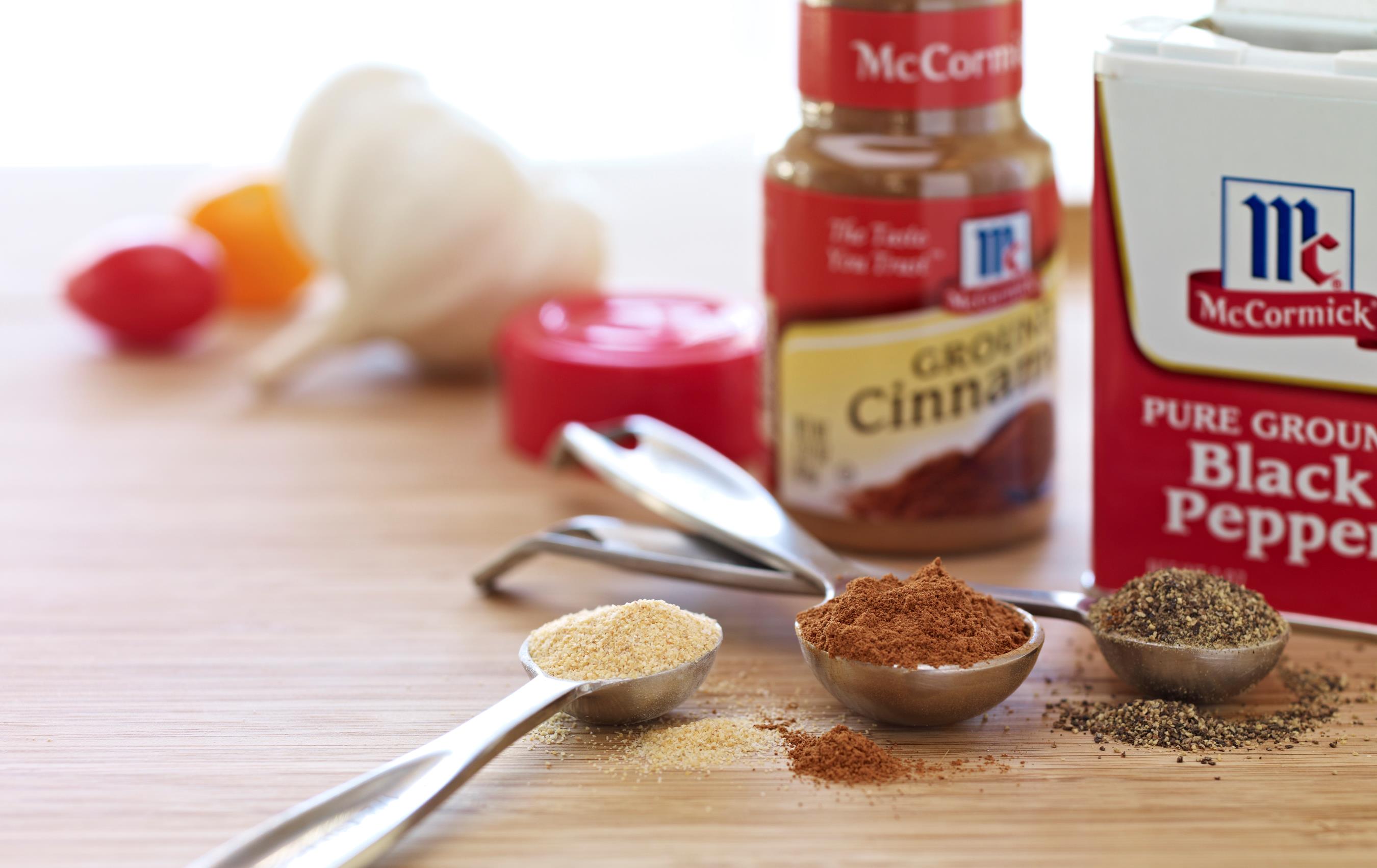 Packages of McCormick spices with spoonfuls of various spices highlighted.