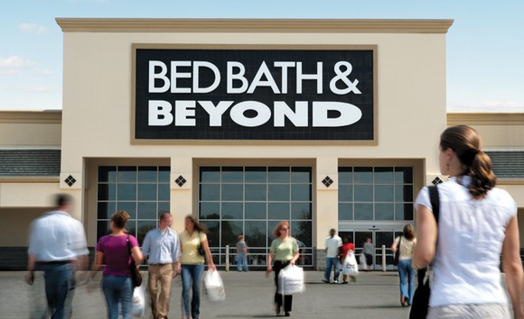 The exterior view of a Bed Bath & Beyond with people walking in.