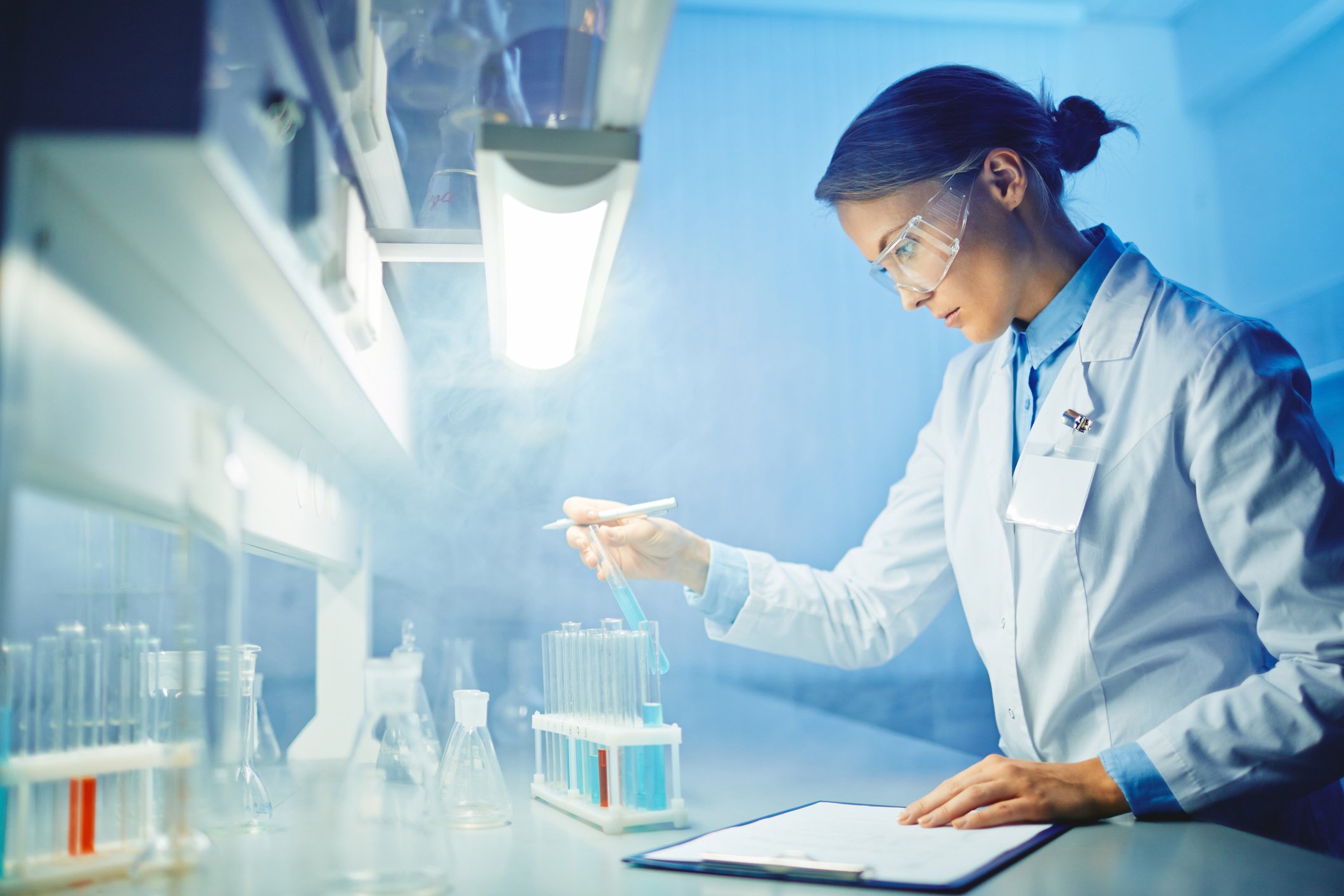 Female scientist in lab examining test tubes