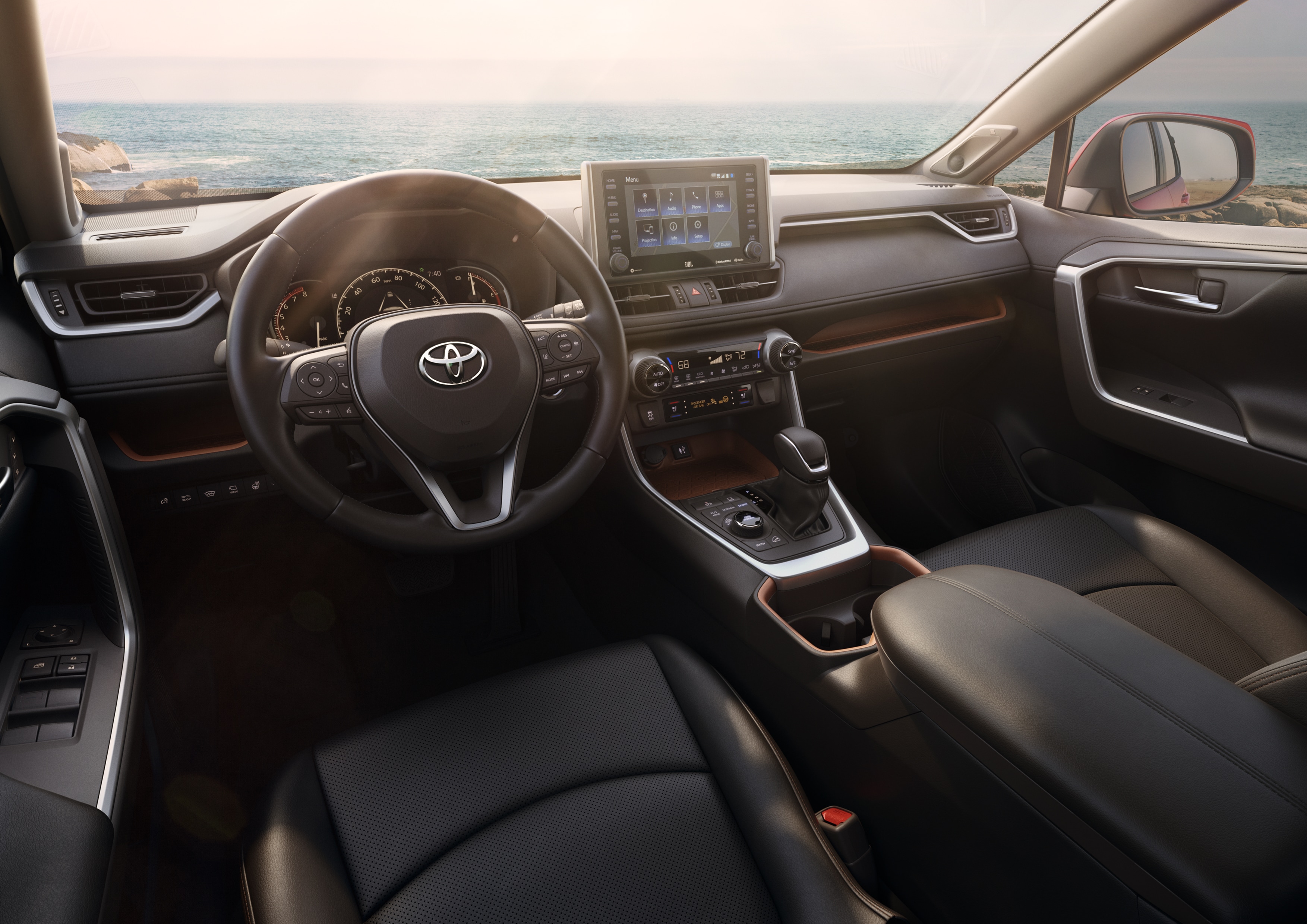 A view of the 2019 RAV4's front seats and dash, showing black leather trim with brushed-metal accents.