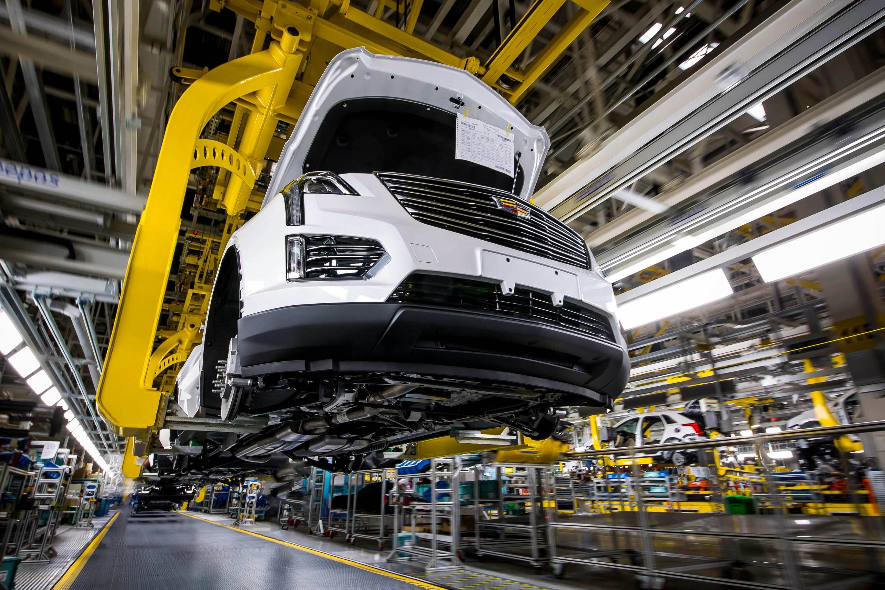 A partially assembled Cadillac XT5 SUV is shown on a factory assembly line.