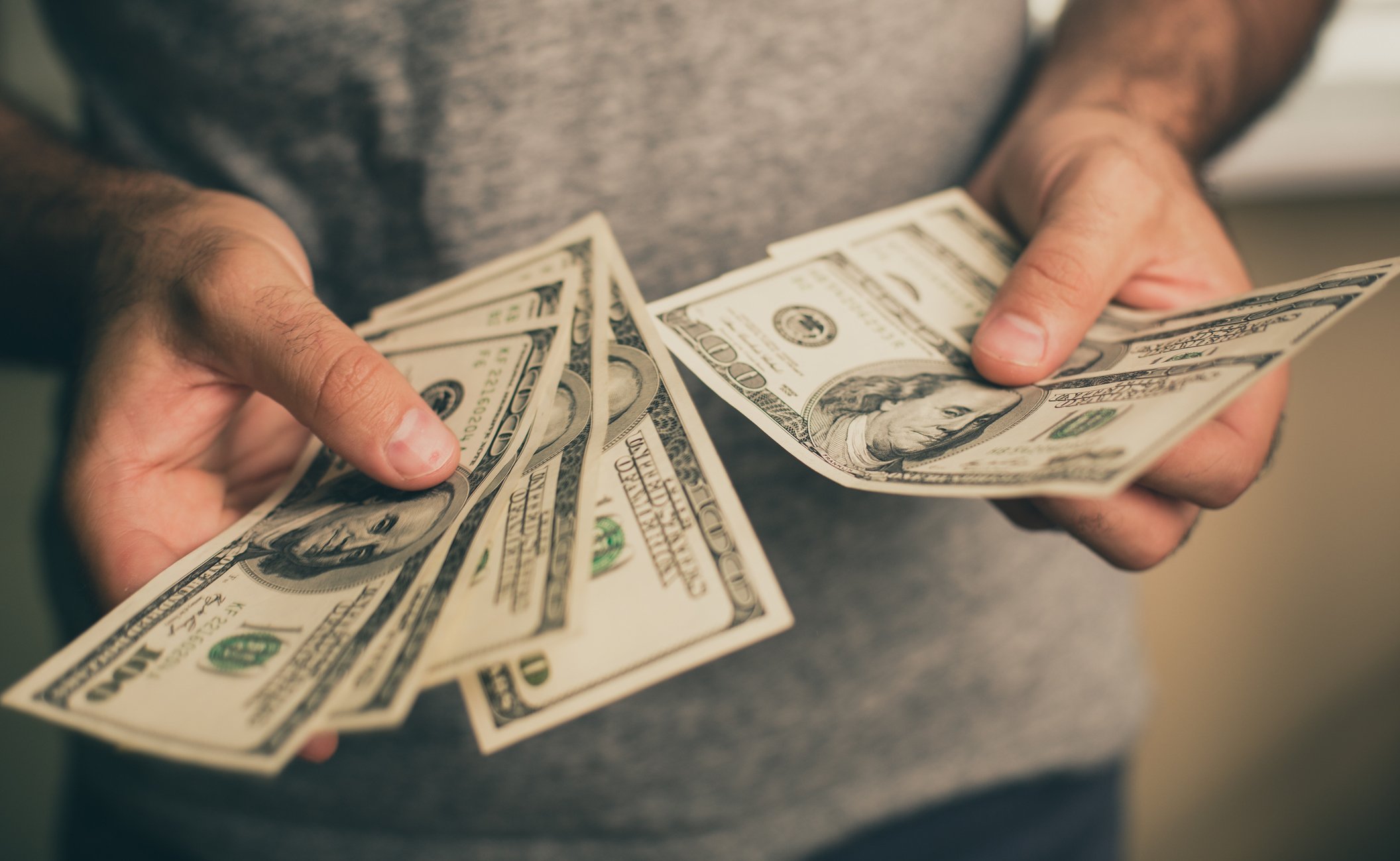 Man holding $100 bills.