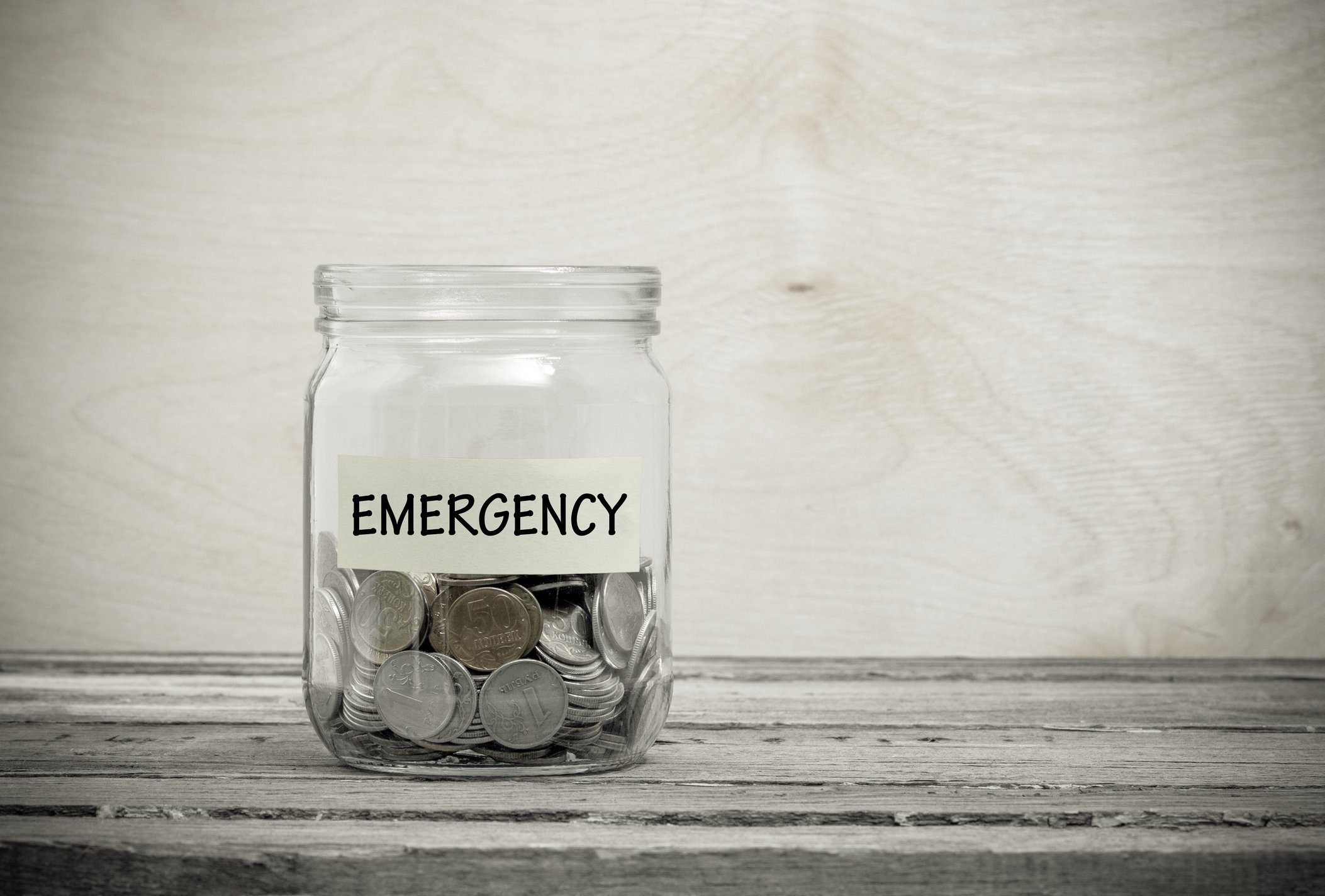 A jar labeled Emergency filled with coins