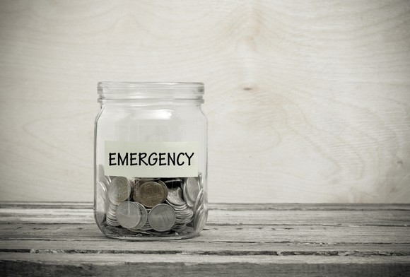 A jar labeled Emergency filled with coins