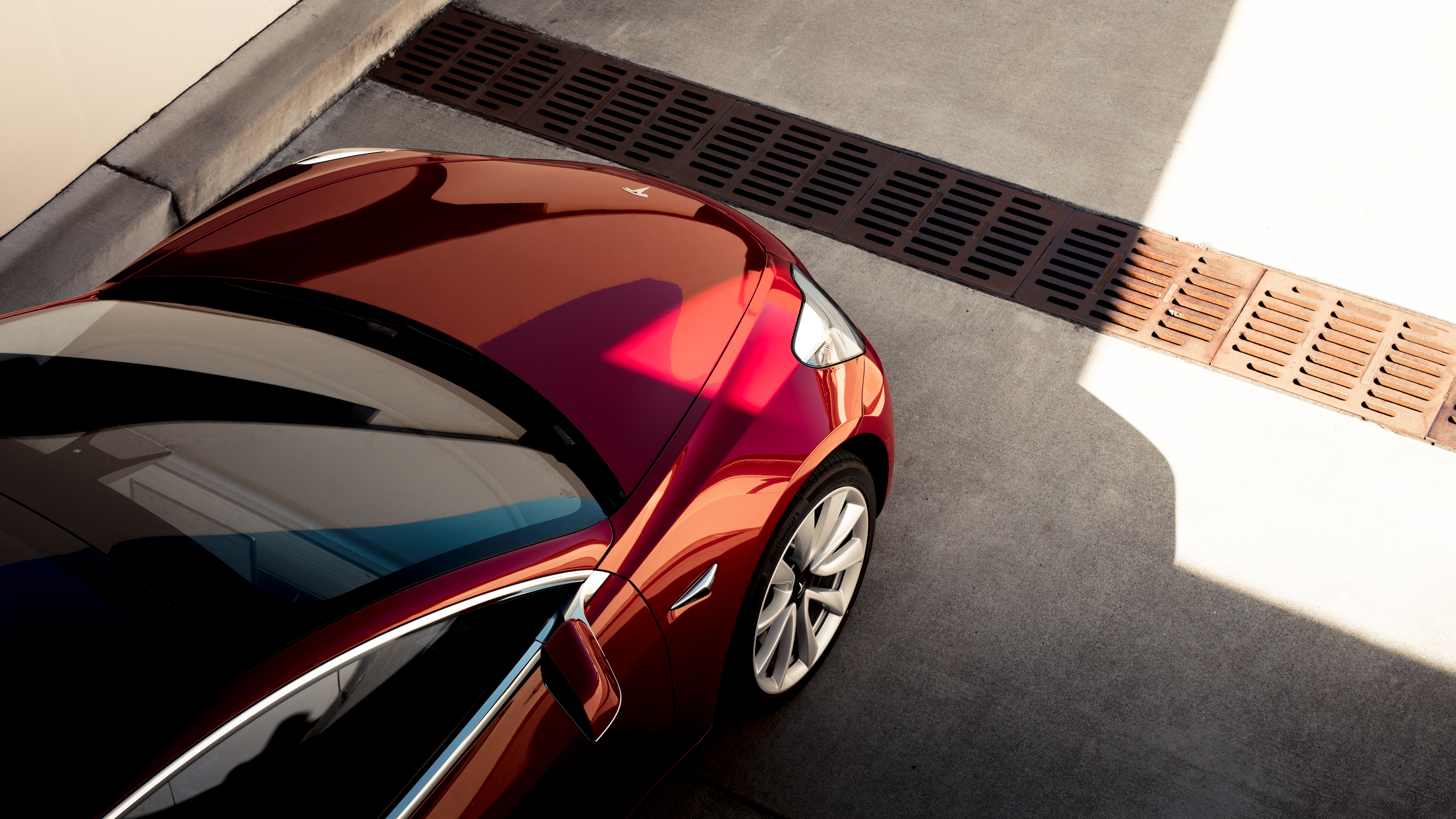 An ariel view of the front end of a red Model 3.