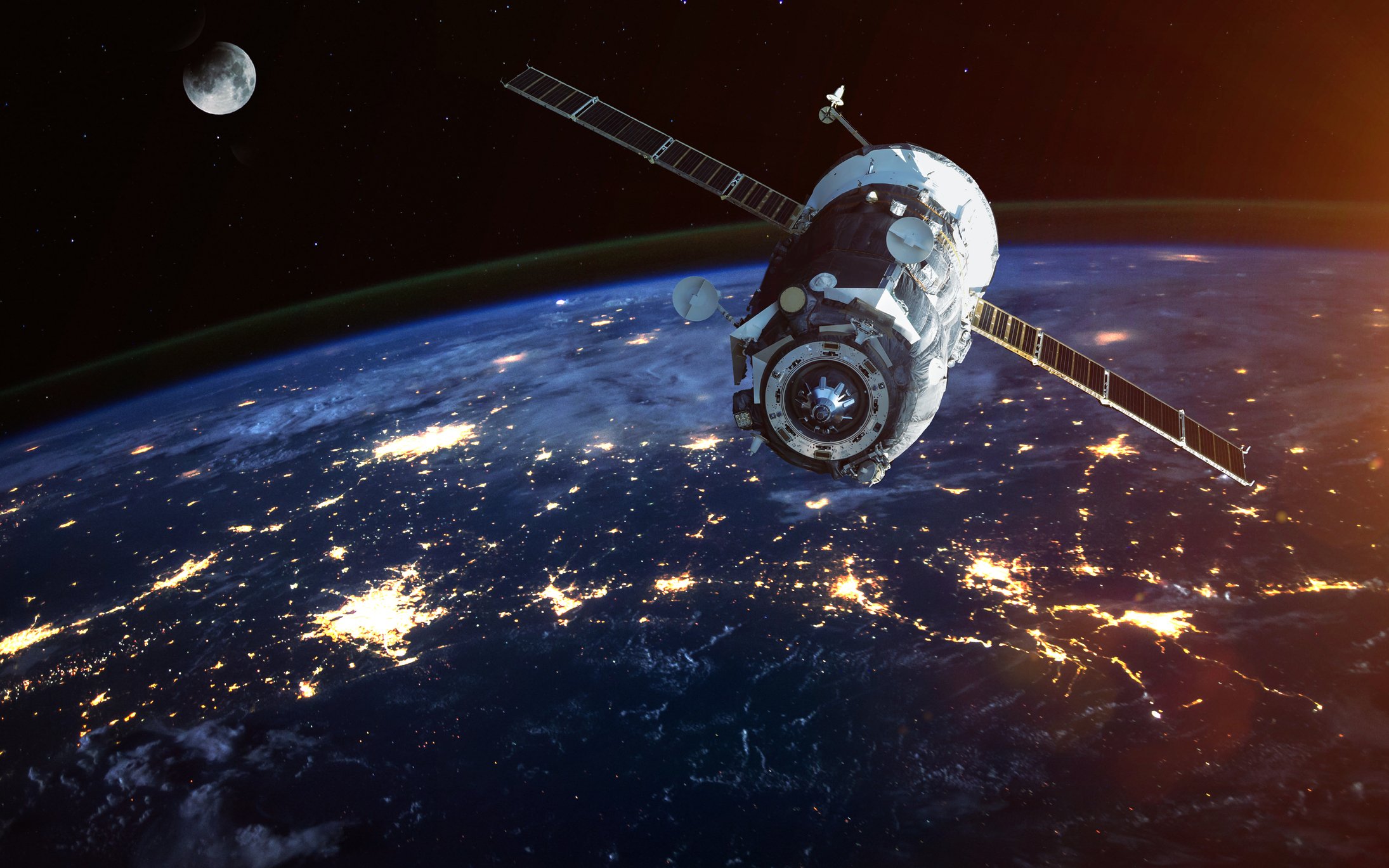 Satellite floating above city lights at night