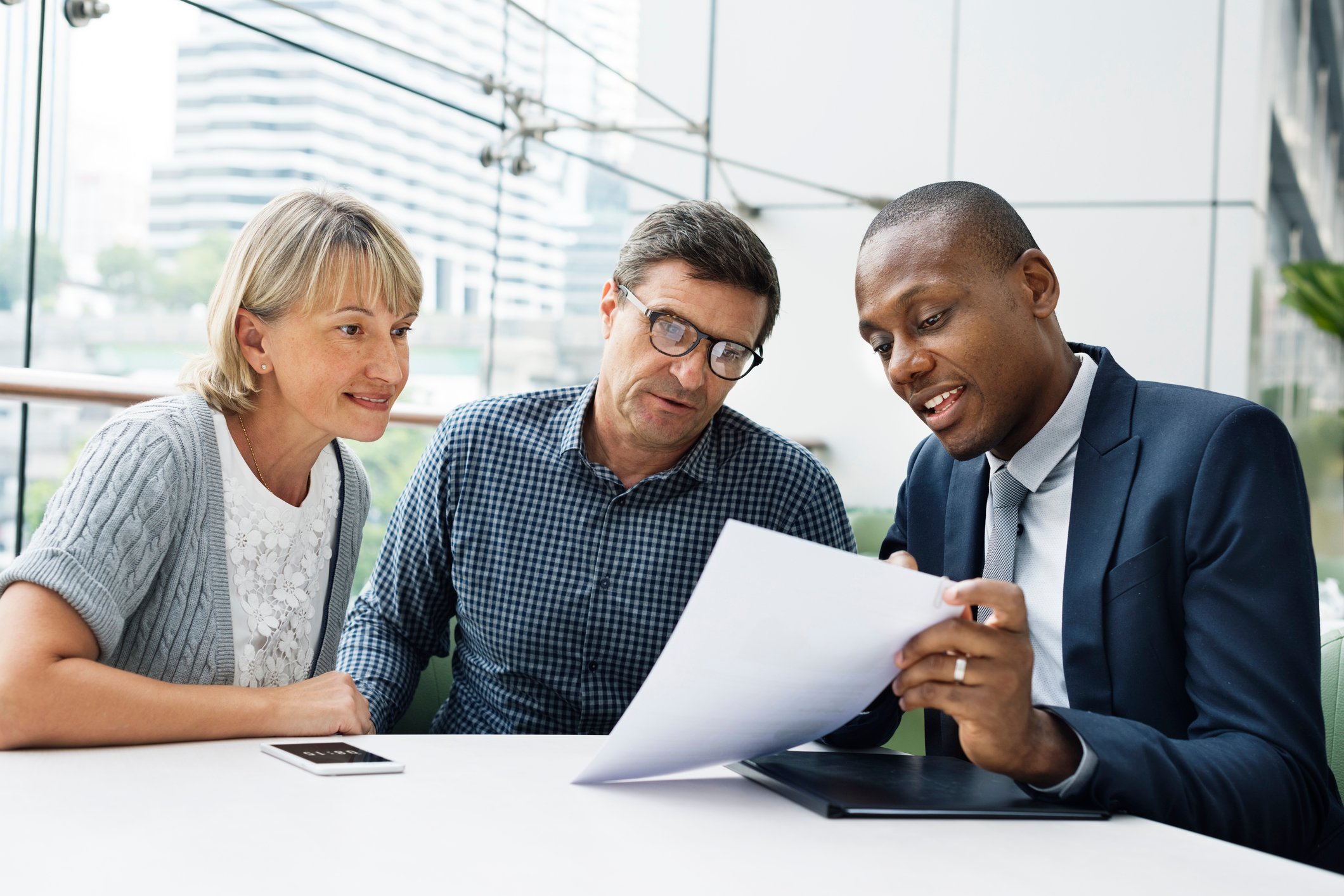 Couple reviewing document with man in suit