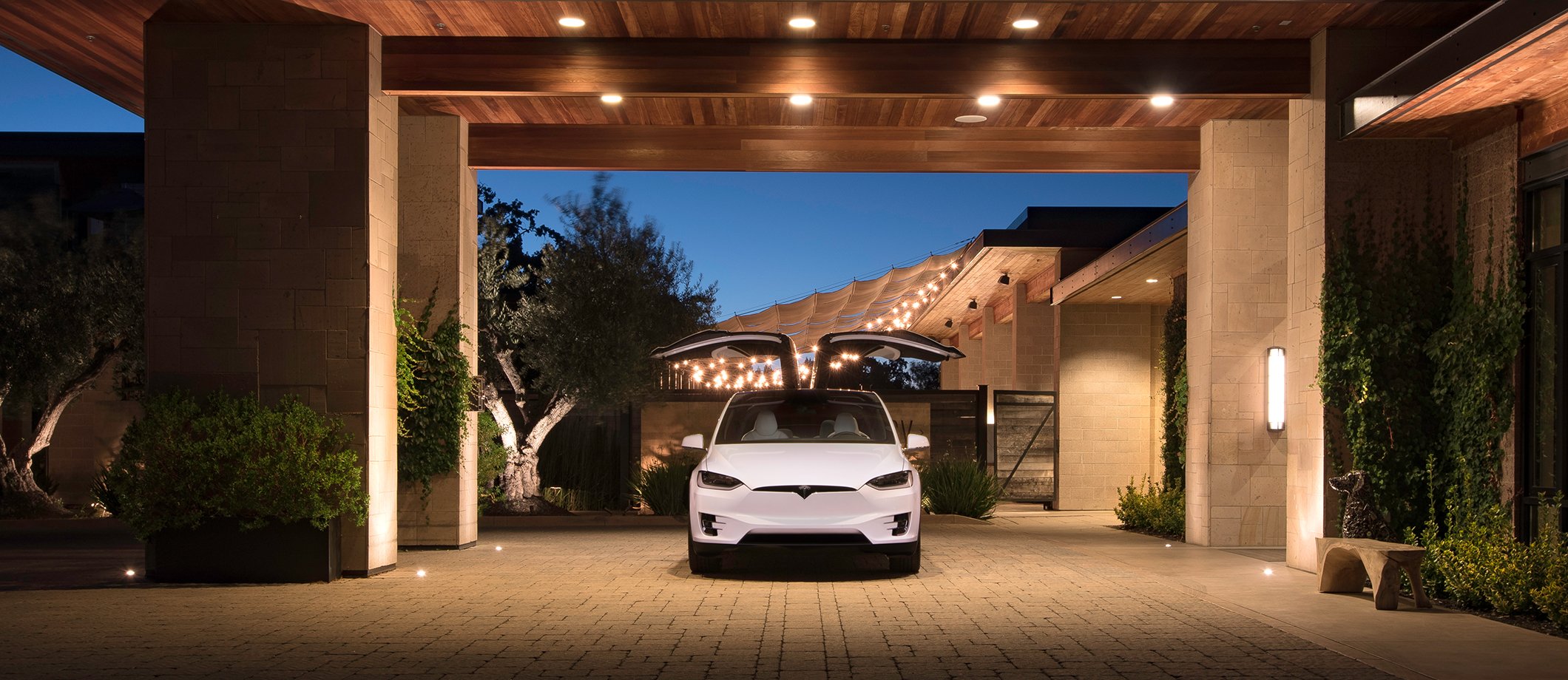 A white Model X with falcon wing doors open.