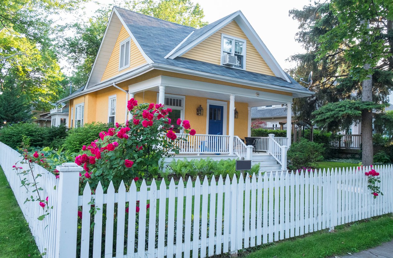 Yellow house with picket fence.