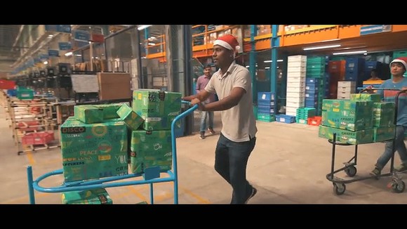 A Flipkart warehouse worker moves a cart of merchandise.