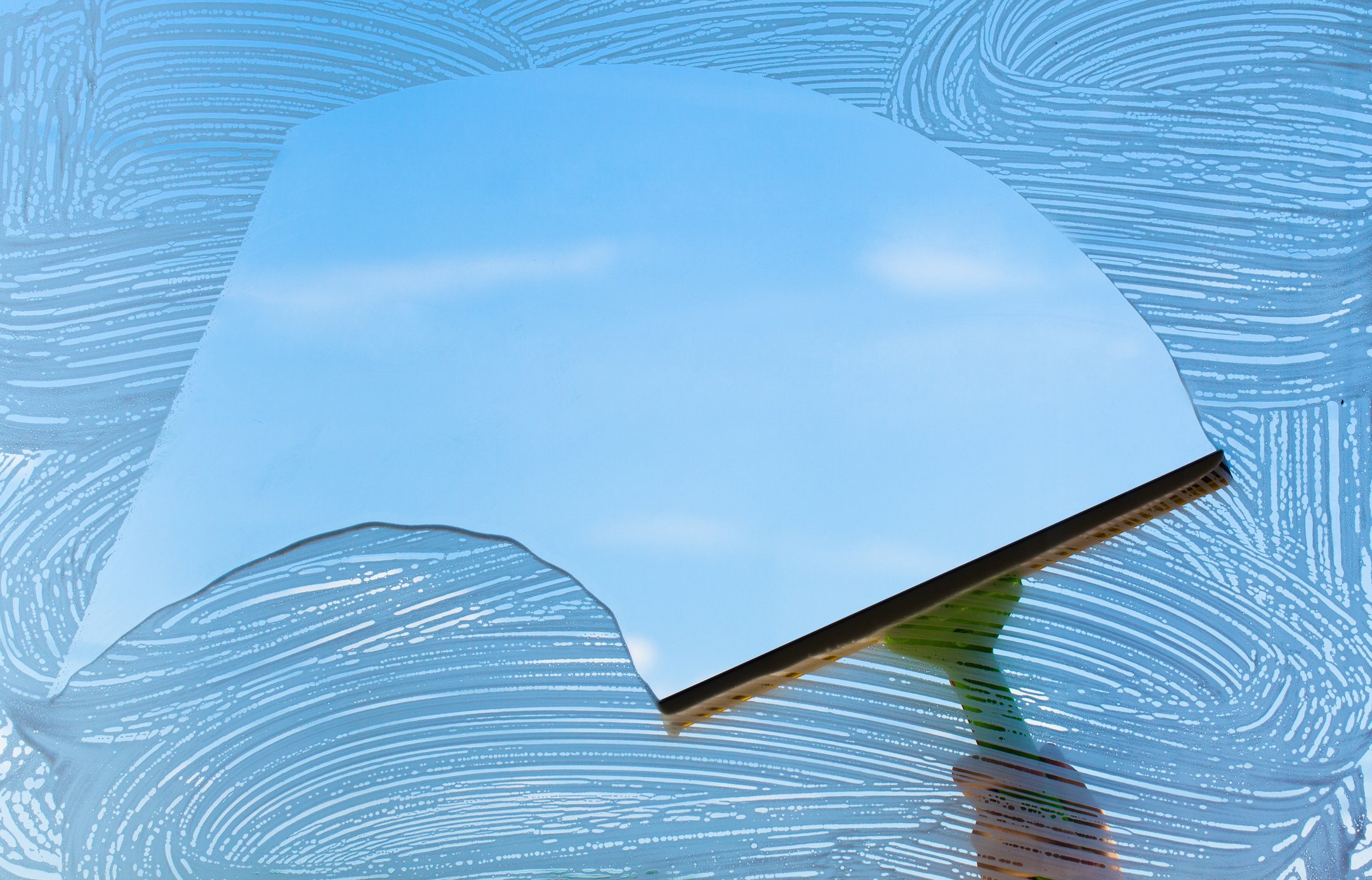 Window being scraped clean with a squeegee