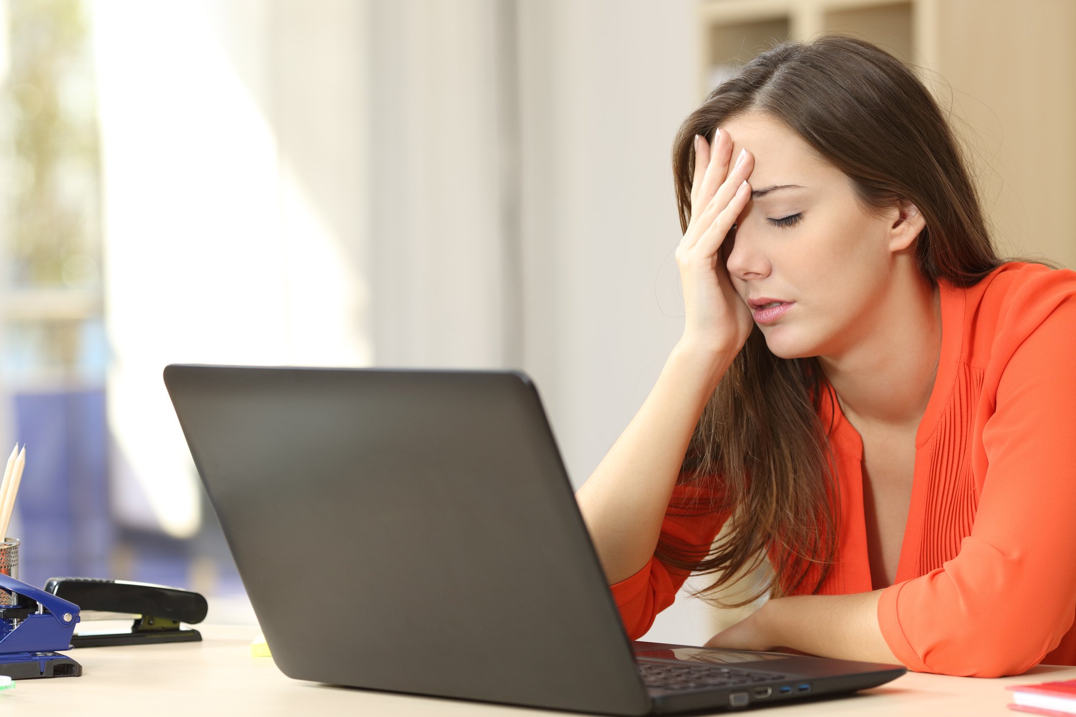 A woman looks frustrated and puts her hand on her head.