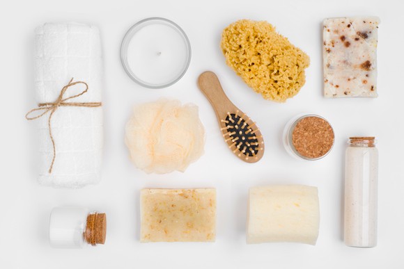An assortment of soaps, salts, scrubbers, for a bath shown on a white background.