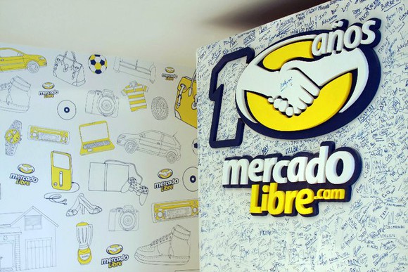 A wall with the MercadoLibre log and employee signatures. 