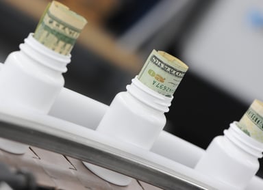 Drug Manufacturing With Money in Bottles Getty
