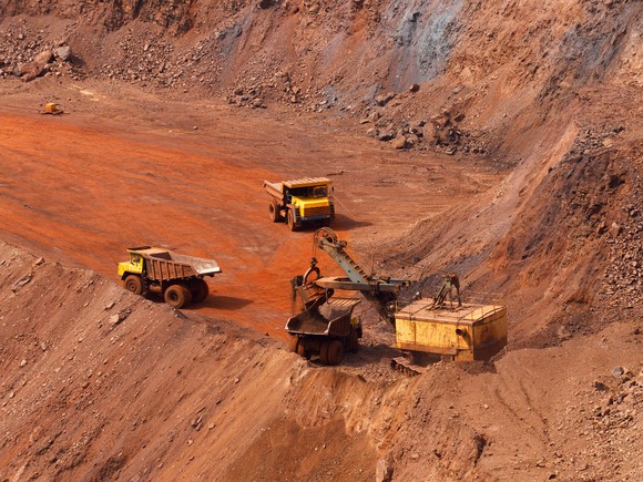 Excavator loading trucks in an iron ore mine.