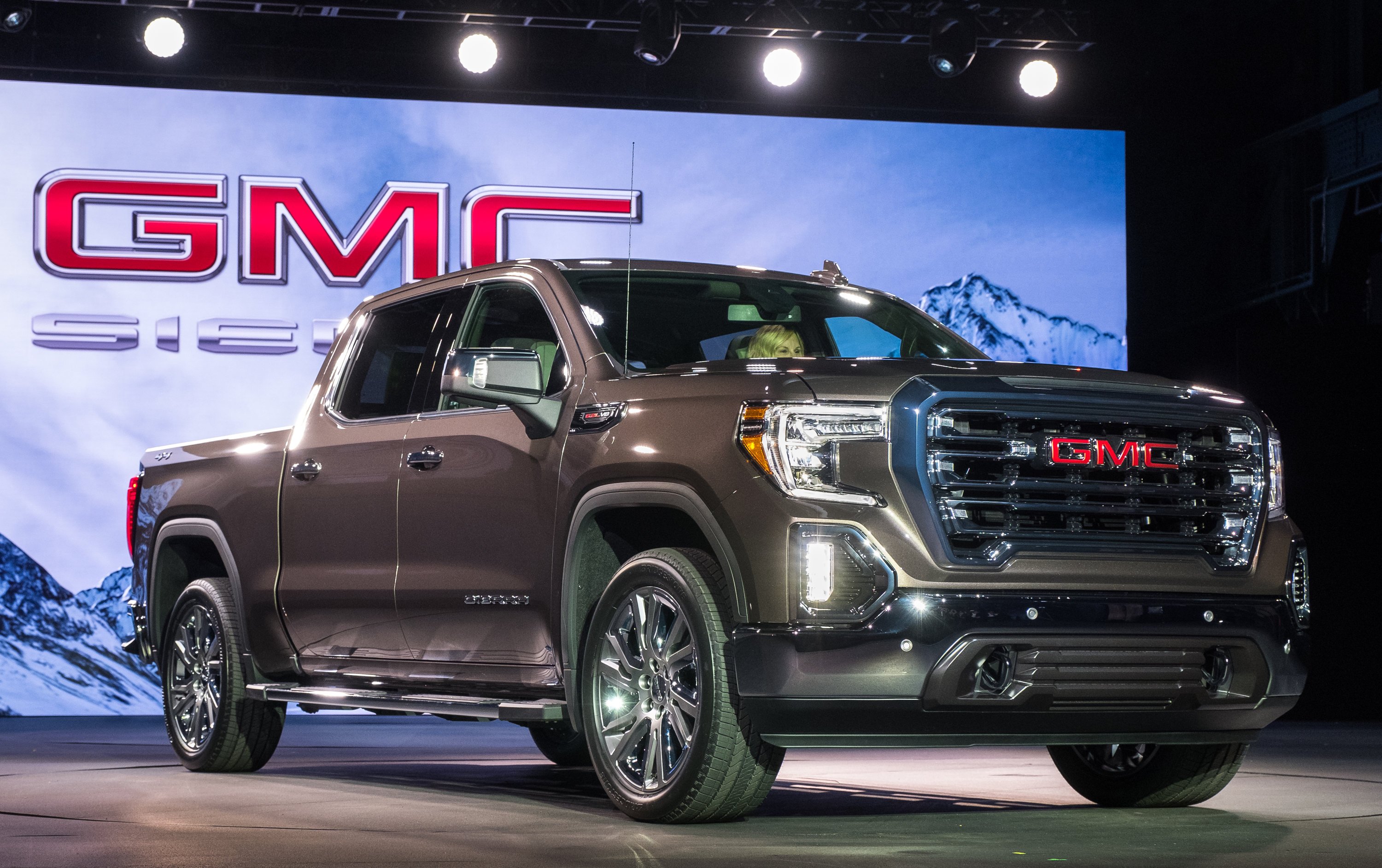 A dark gray 2019 GMC Sierra pickup on a show-car stand