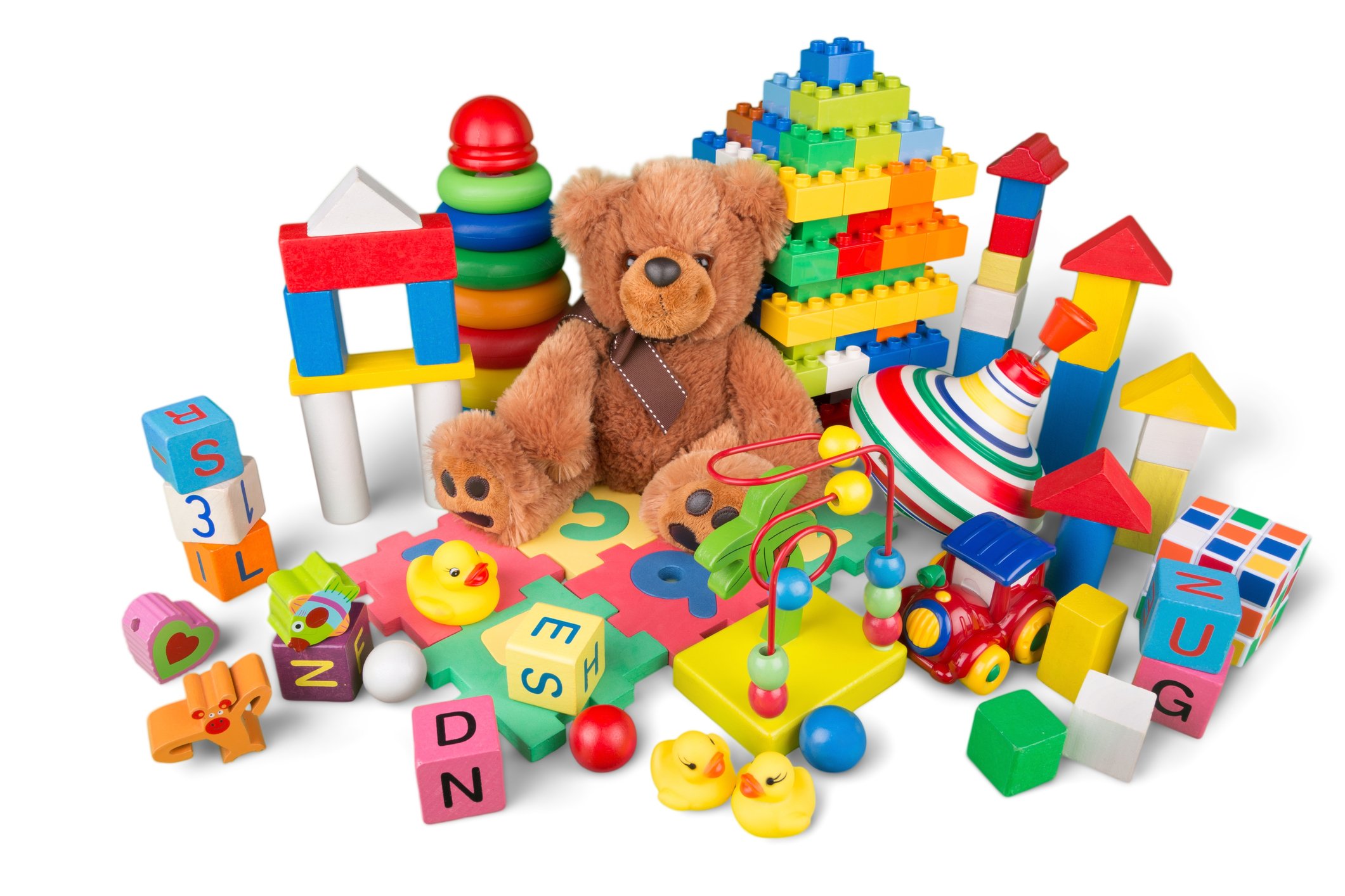 A teddy bear surrounded by plastic toys.