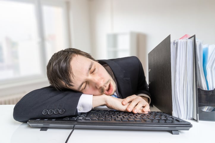 A businessman sleeping at his desk.