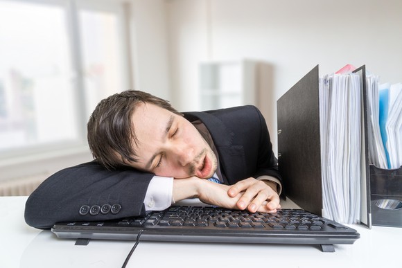 A businessman sleeping at his desk.