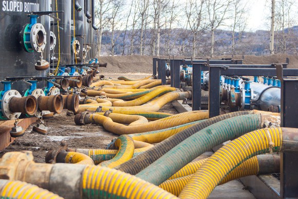 Frack sand rigs with hoses, situated at a rig.