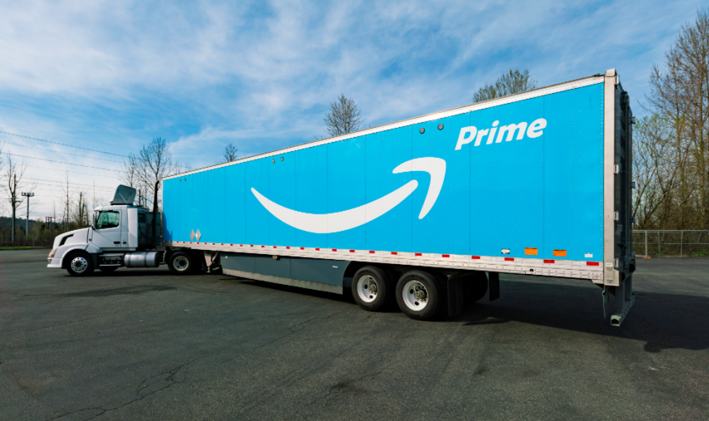 An Amazon delivery truck is painted blue with an Amazon Prime logo on it