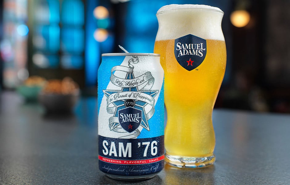 A can of Boston Beer's Sam '76 beer sitting next to a full Samuel Adams pint glass