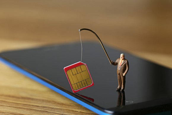 A tiny businessman, standing on a phone, holds a SIM card on a fishing rod.
