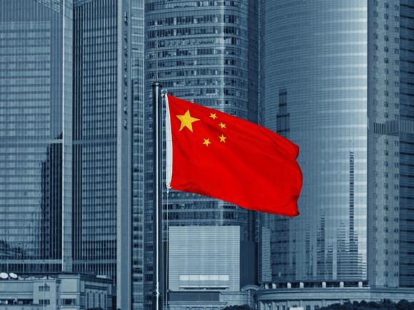 A Chinese flag with skyscrapers in the background.