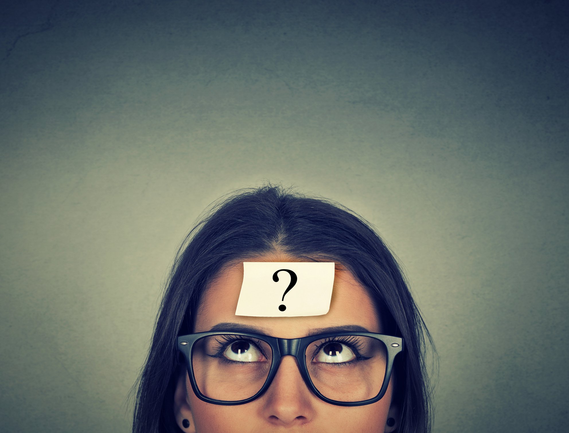 Woman with Post-it not on her head with a question mark on it.